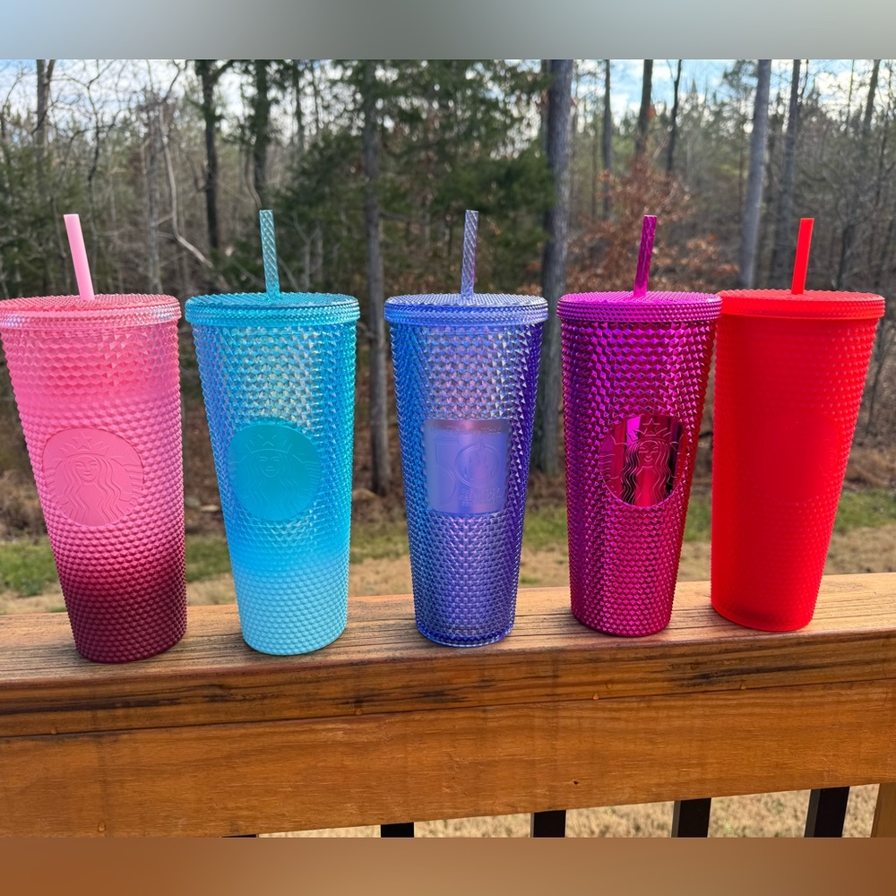 A colorful collection of Starbucks studded cups including a LE Disney 50th